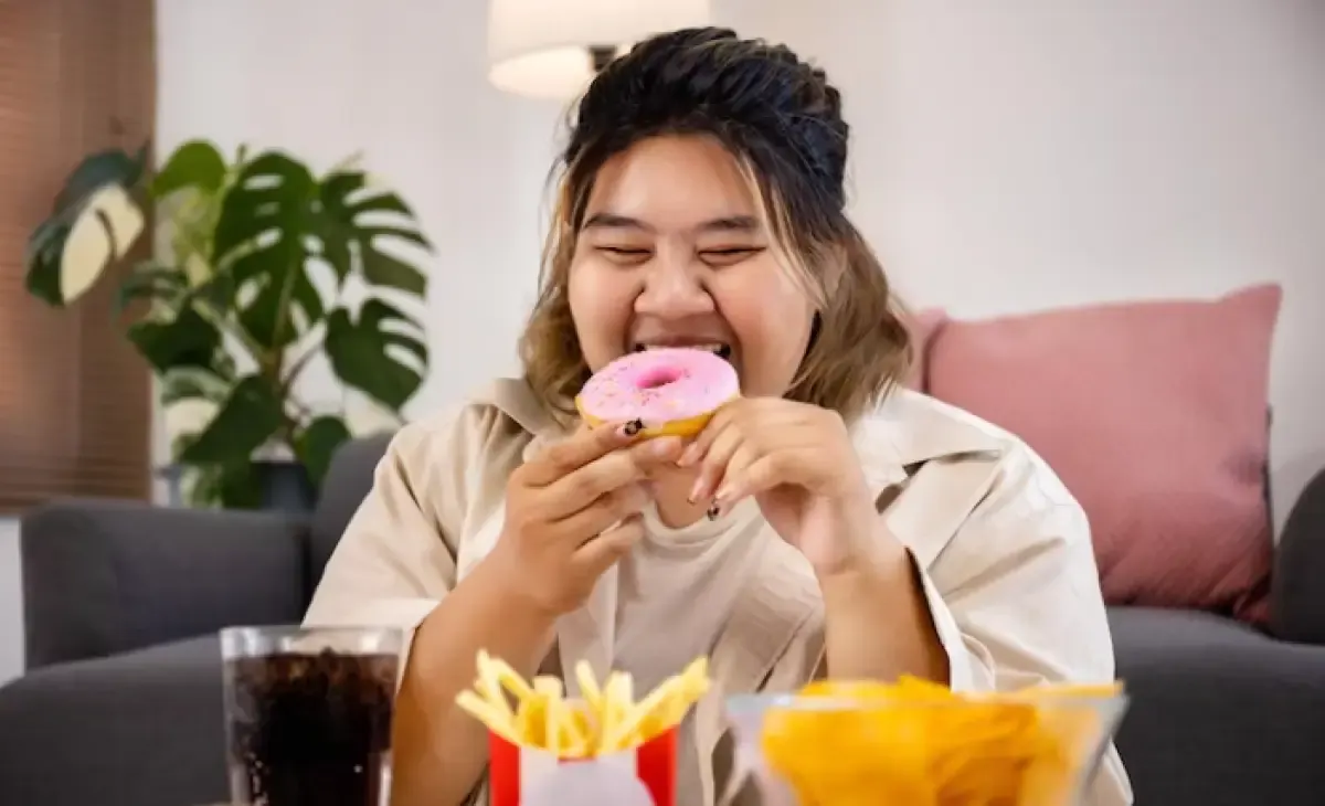 Ilustrasi seorang wanita sedang makan banyak yang bisa sebabkan kegemukan. (Sumber : Freepik.com/studioredcup)