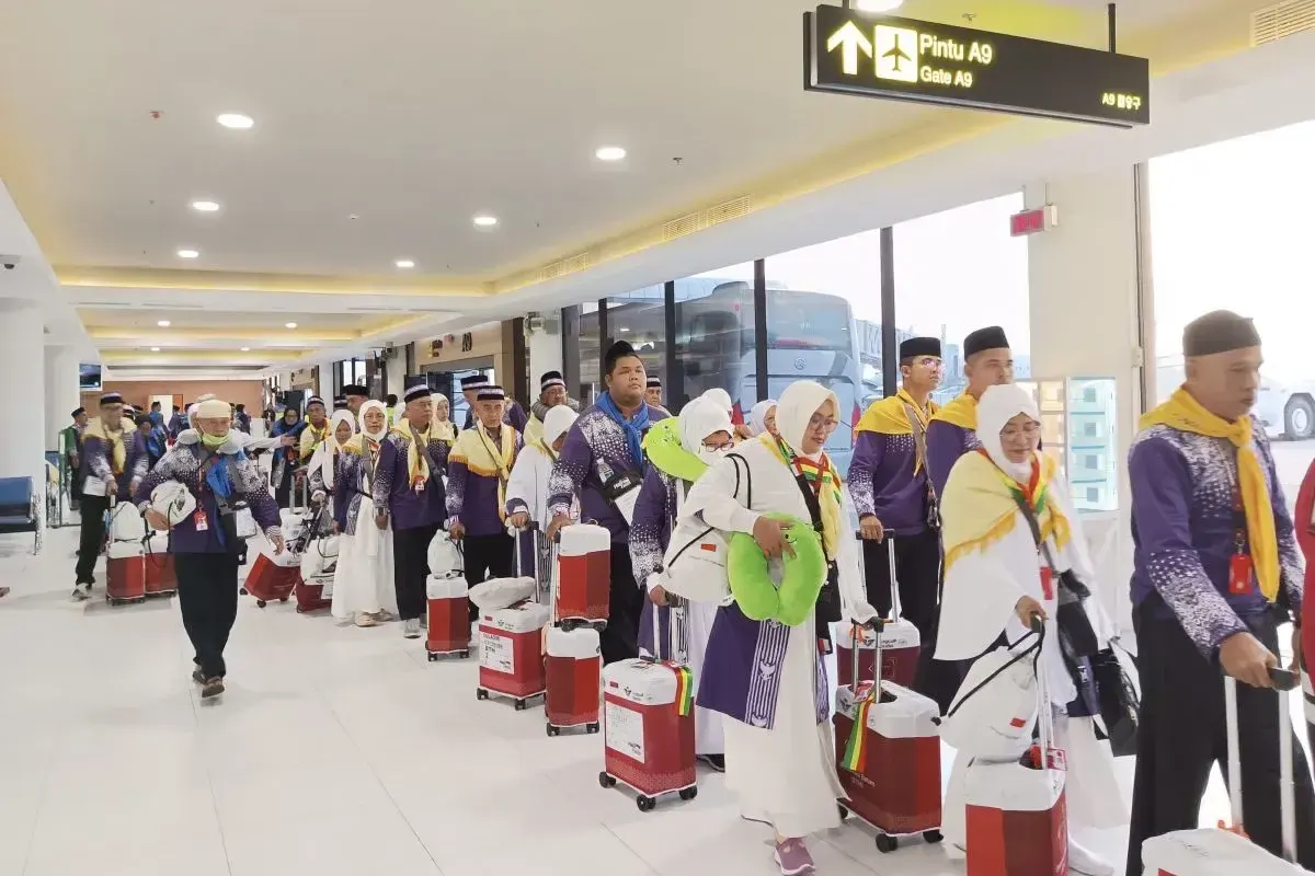 Jamaah calon haji (JCH) sedang berjalan menuju pintu gerbang pesawat untuk berangkat ke Tanah Suci di Bandara Internasional Hang Nadim Batam. (Sumber: Antara)